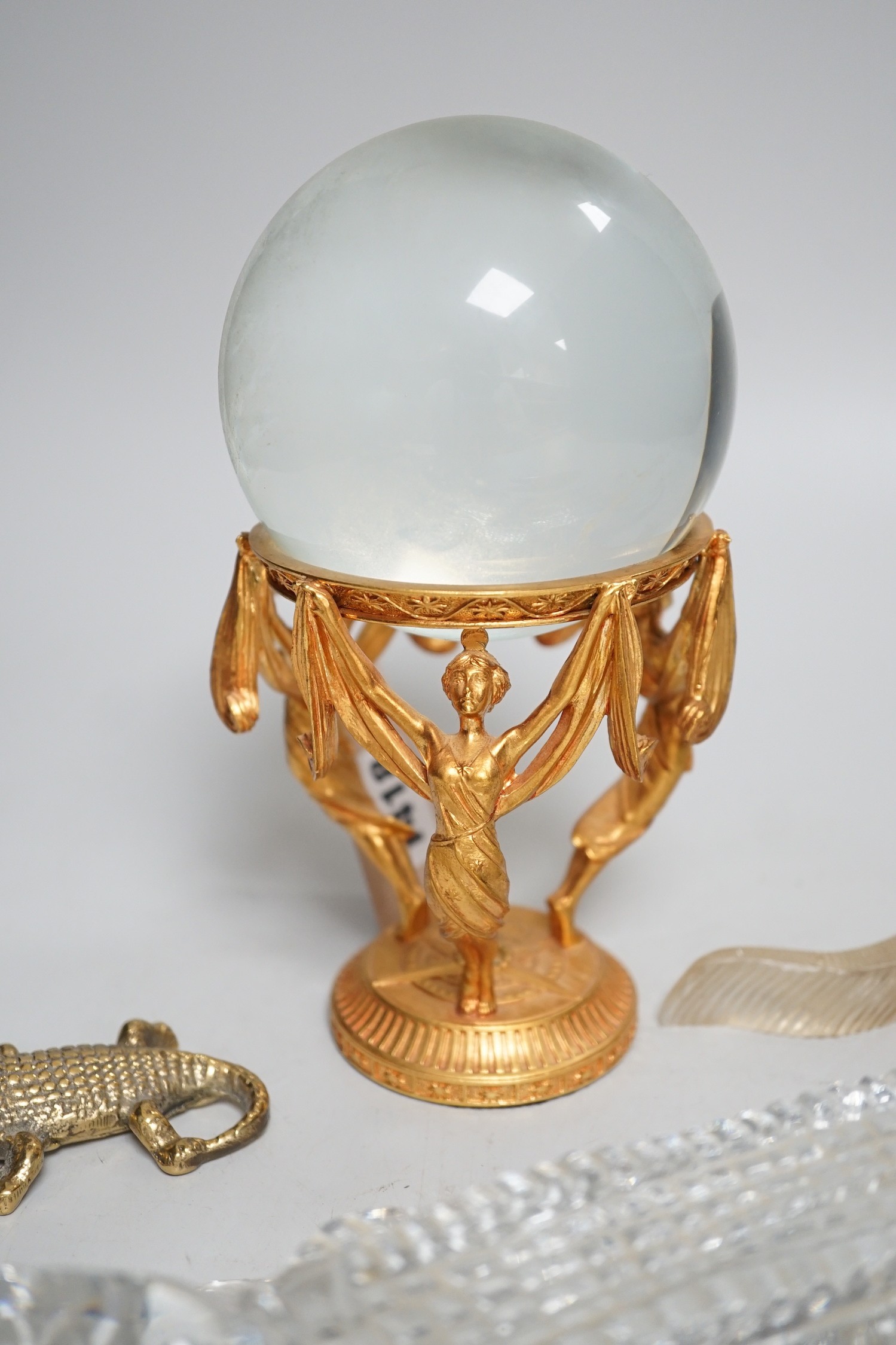 A crystal ball on gilt metal stand, 19cm tall, together with a hermatite crocodile, a jade type crocodile and four other crocodiles